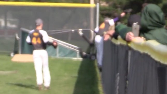 Ryan Socha of Avon (OH) ran a long way to get to this ball. Socha climbs the fence and reaches over to bring this ball back and make the terrific catch.