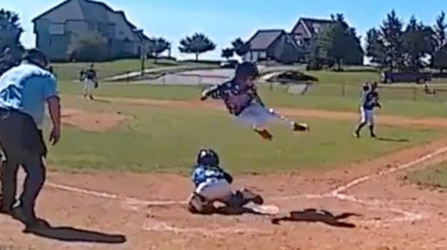 11-year-old CJ Wallace of the Manalapan Braves (NJ) youth baseball team leaps completely over catcher, Garrett McGovern, to score the game-winning run. This walk-off run won the game for the Braves after trailing 10-1.