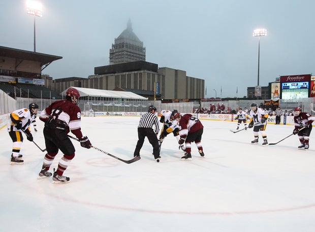 A portion of the Rochester skyline looms in the background as players from McQuaid Jesuit and St. Joseph's Collegiate face off.