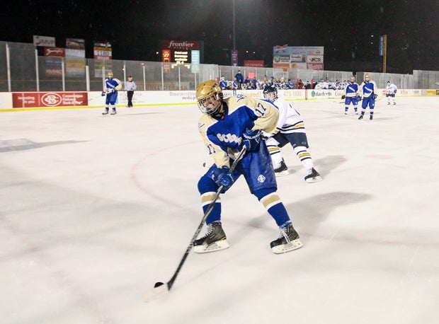 A Webster Schroeder player protects the puck from a Webster Thomas forechecker.