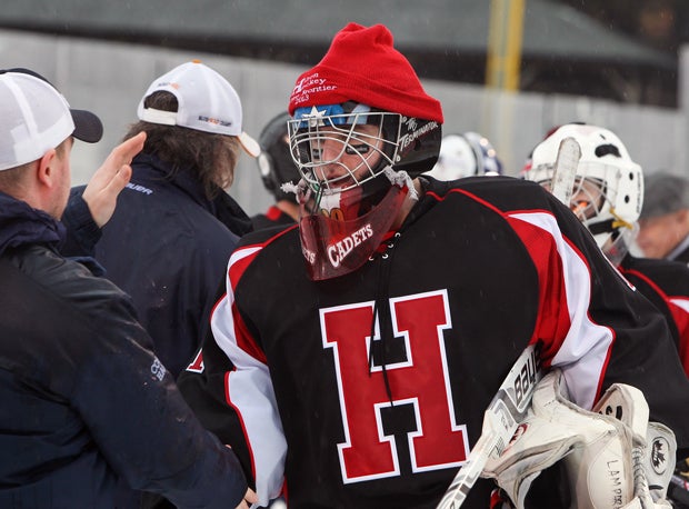A Hilton goalie stays warm and dry with a ski hat as he shakes hands with Irondequoit players and coaches.