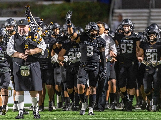 Jacob Manu leads Servite onto the field Friday against Orange Lutheran.