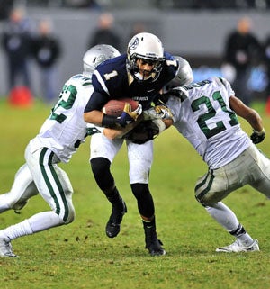 A St. John Bosco runner is about to be 
sandwiched at last year's state open Division
bowl championship in Carson. 