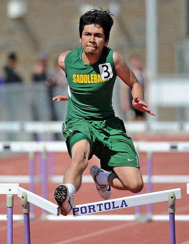 A Saddleback (Calif.) track athlete breaks through a hurdle while competing in the Earl Engman Relays in Southern California.