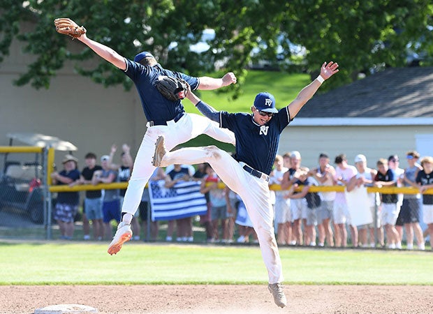 Two Pleasant Valley (Iowa) players leap while celebrating the final out in a victory over host Assumption on June 15 in the first baseball game of the season in that state following the shut down for COVID-19. 