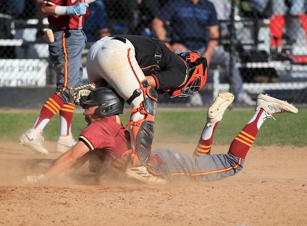 A La Canada runner slides head first at home between the South Pasadena catcher's legs. (Photo: Rene Morales)