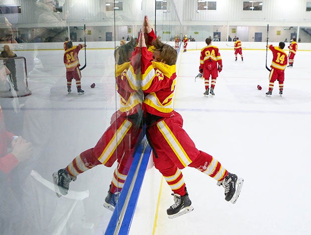 Tommy Olson of Bergen Catholic (N.J.) leaps into the boards to celebrate with fans after defeating Don Bosco Prep in the Bergen County Tournament title game.