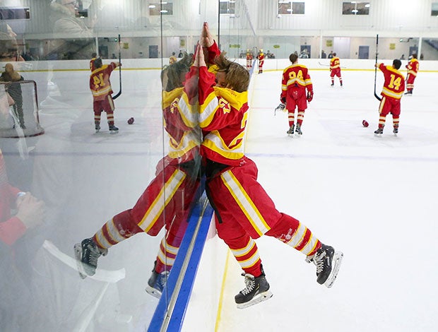 Tommy Olson of Bergen Catholic (N.J.) leaps into the boards to celebrate with fans after defeating Don Bosco Prep in the Bergen County Tournament title game. 