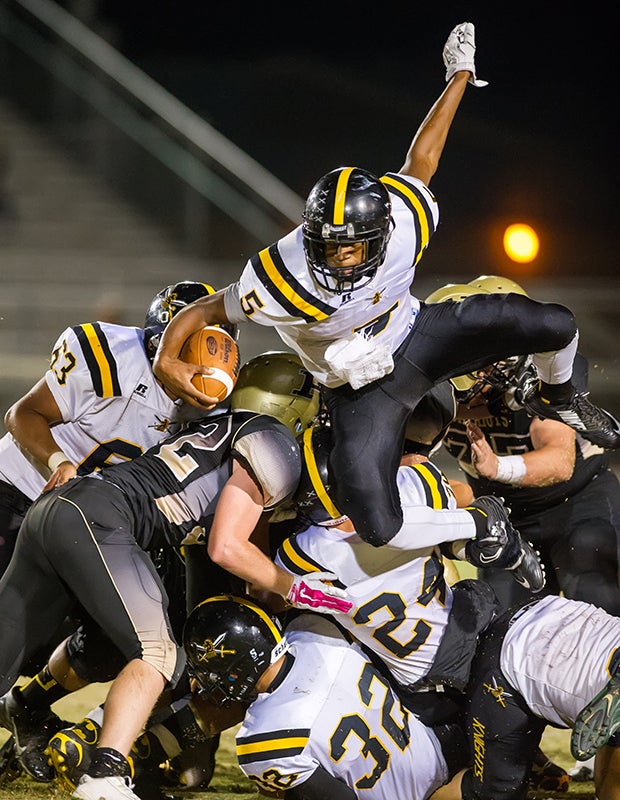 Rio Linda (Calif.) running back Zethan Dumpson leaps over a pile of players during a game against Pioneer. 