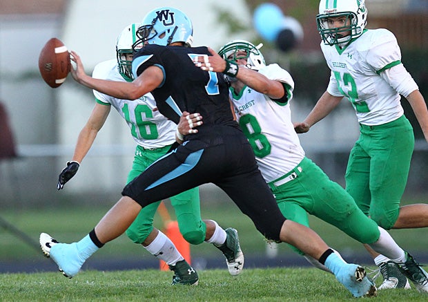 Colton Michaelsen of West Jordan (Utah) tries to get rid of the ball as Hillcrest (Midvale, Utah) tacklers converge.