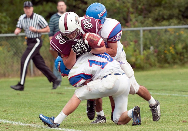 Londonderry (N.H.) tacklers knock the ball away from a Goffstown (N.H.) player.