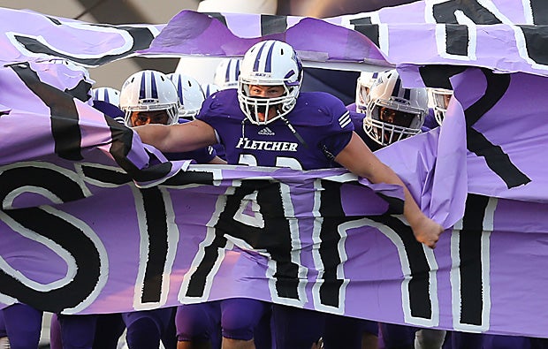 Fletcher (Neptune Beach, Fla.) blasts onto the field before its game against Sandalwood (Jacksonville, Fla.).