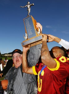 Lincoln coach Phil Ferrigno and
tailback Demetrius Williams
hold up Turkey Day Game trophy
up Thursday after 22-21 win over
Mission.
