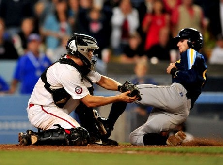 Harvard-Westlake catcher Arden Pabst tags out Marina's Tyler Mildenberg at the plate Friday at Dodger Stadium. The seventh-inning play helped secure a 1-0 victory and a section title.