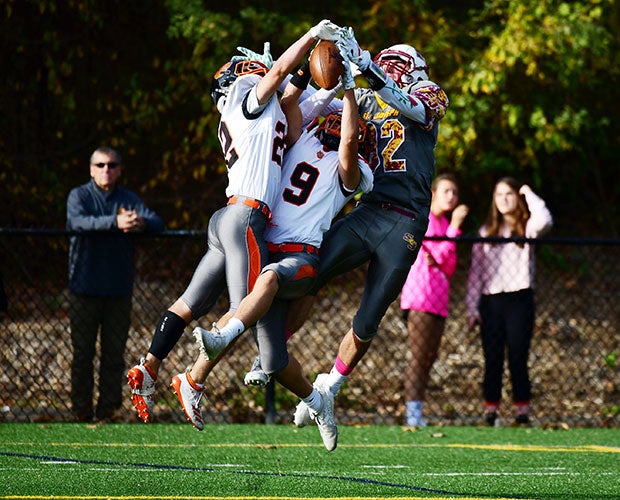 Ridgefield (Conn.) defensive back Dean Habeeb (middle) intercepts a pass intended for St. Joseph receiver Will Diamantis (right).