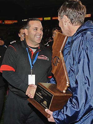 Centennial coach Matt Logan receives the state title
trophy in 2008.
