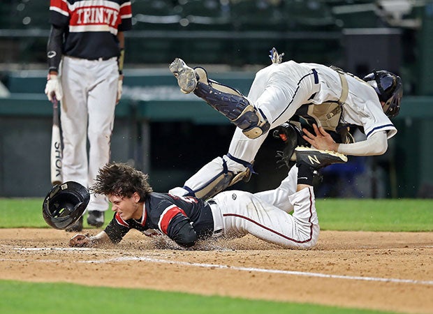 A Trinity (Euless, Texas) base runner is out after colliding with the Flower Mound catcher in a UIL 6A playoff game at Globe Life Park, home of the Texas Rangers.
