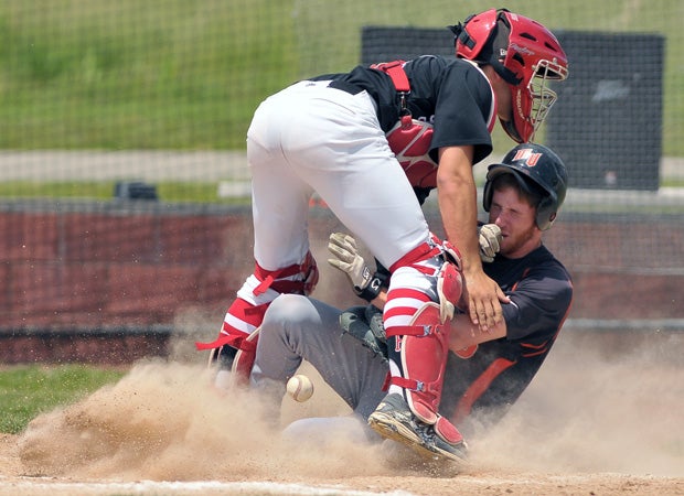 A Mt. Vernon (III.) player scores the winning run in the bottom of the seventh inning as the ball is jarred loose from the Highland catcher during a game in May. 
