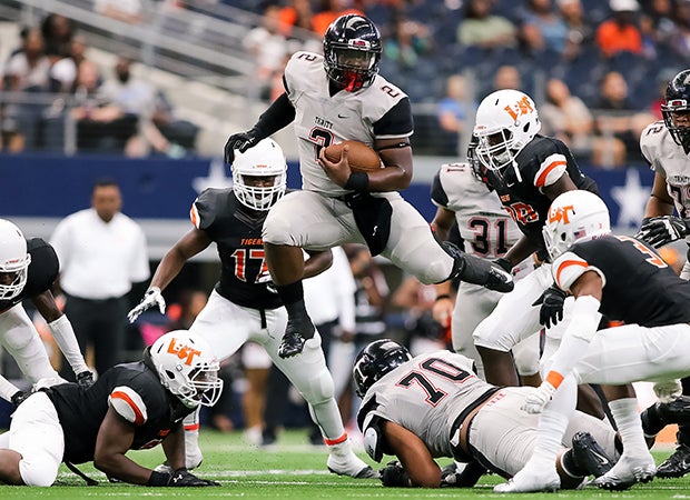 Trinity (Texas) running back Tyler Natee soars over players while carrying against Lancaster.