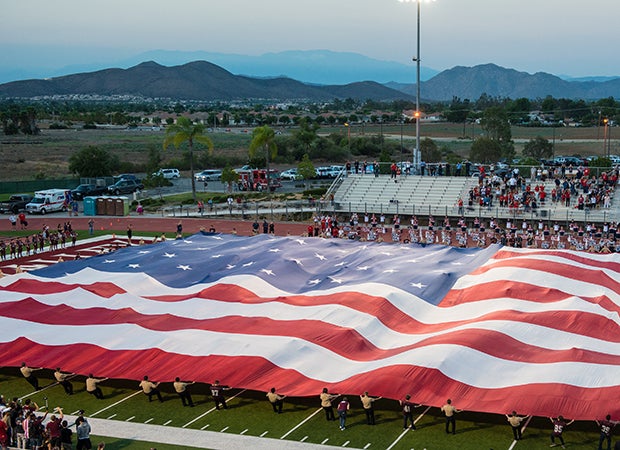 A large American flag covers the field in honor of 9/11 remembrance before the King at Paloma Valley varsity football game in Southern California.