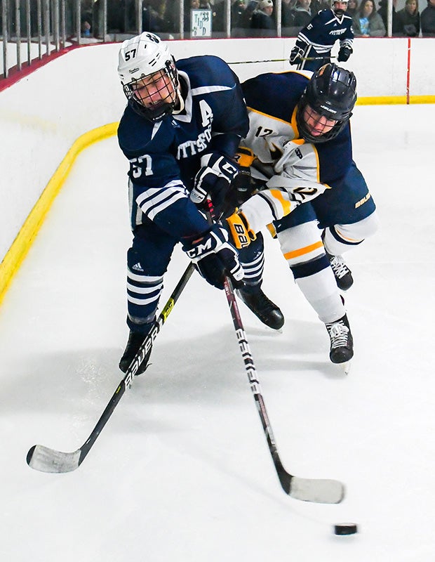 Brendan Halms of Pittsford (N.Y.) and Liam Moore of Victor reach for the puck along the boards.  