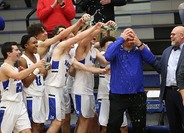 Maiden (N.C.) players douse head coach Danny Anderson with cups of water while celebrating his 700th coaching victory.