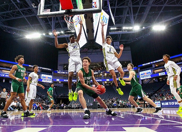 Two Grant (Calif.) players leap while defending St. Mary's forward Bryce Johnson during the CIF Sac-Joaquin Section Division 2 title game at Golden 1 Center in Sacramento.