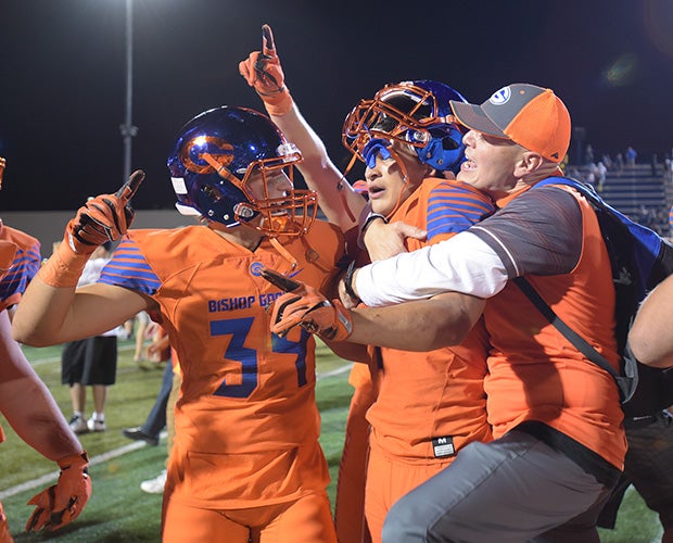 Biaggio Ali Walsh (middle) celebrates with teammate Murphy Boudreaux and an assistant coach following his game-winning, 2-point conversion run.
