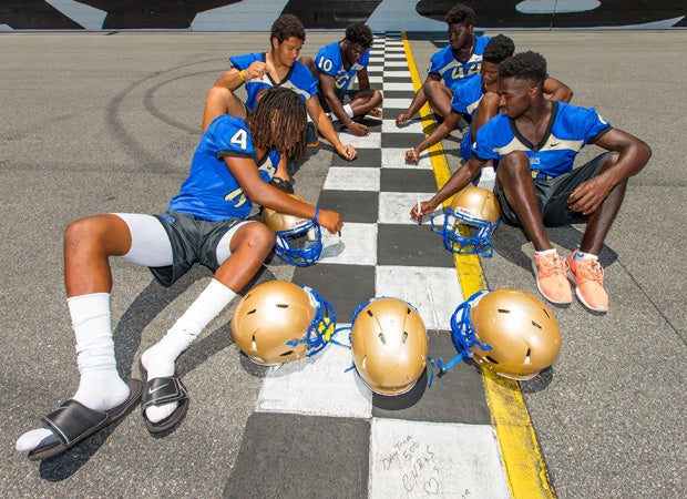 The players involved in the photo shoot sign their names on the start/finish line.