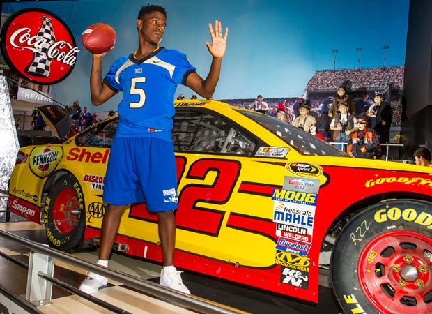 Quarterback Denzel Houston poses in front of 2015 Daytona 500 champion Joey Logano's car.