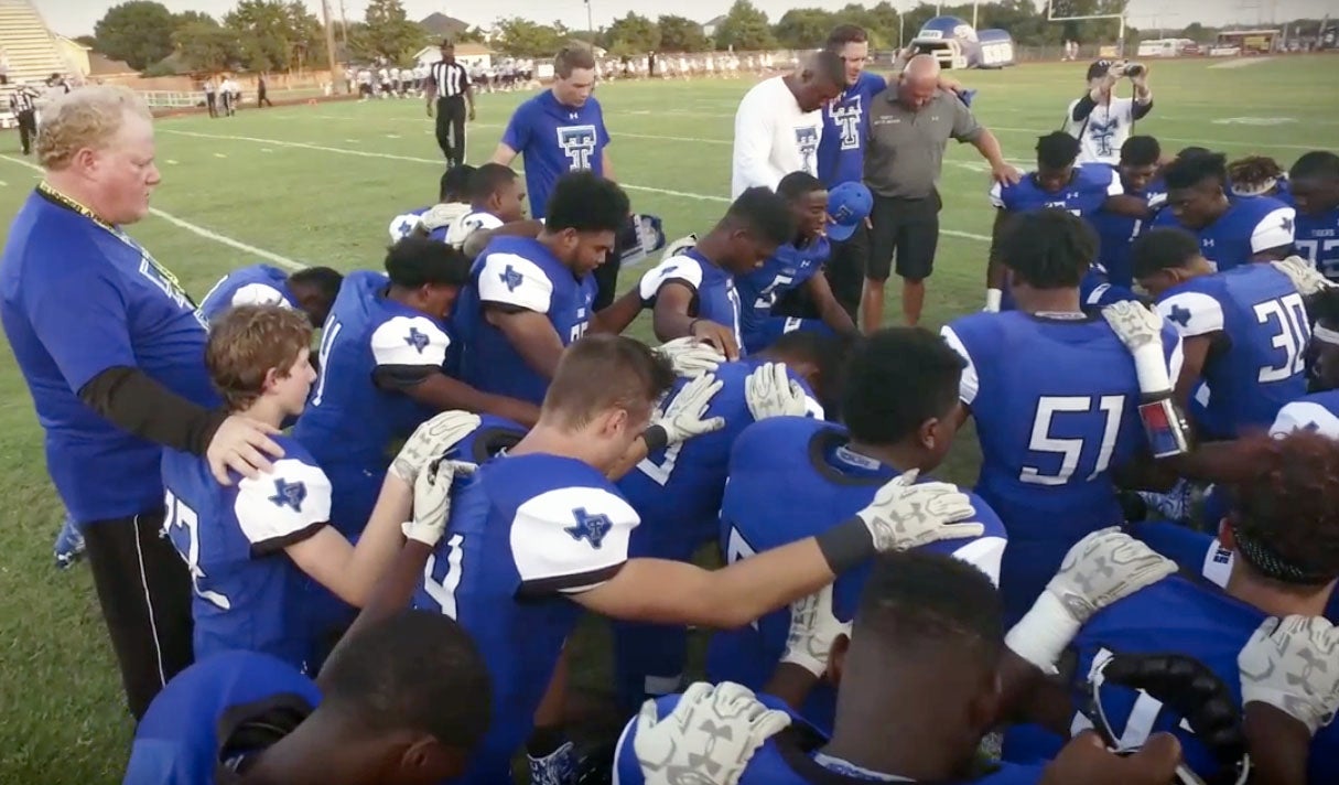 Trinity Christian takes a knee following its season opener.