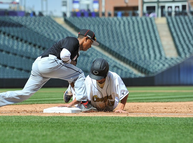 An Evergreen player goes back to first base on a pickoff attempt at Coors Field.