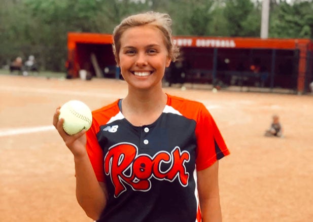 Rockcastle senior pitcher Madison McIntosh holds up the ball used to record her 21st and final strikeout in Tuesday's perfect game vs. Lincoln County.