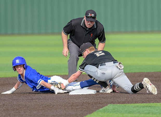 A Midlothian (Texas) base runner is tagged out by a Royse City player after sliding past second base during a UIL 5A Area playoff game.