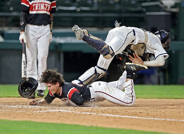 A Trinity (Texas) base runner is called out after colliding with a Flower Mound catcher in a UIL 6A playoff game at Globe Life Park, home of the Texas Rangers.