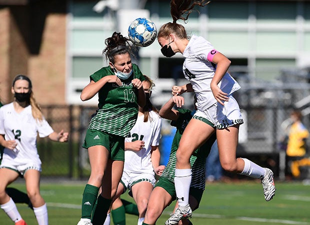 Yorktown (N.Y.) midfielder Chayce Buono (right) attempts to head a shot on goal as she's challenged by a Brewster defender.