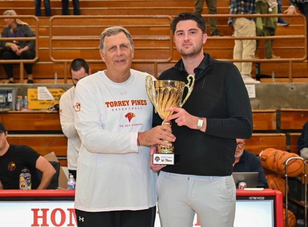 The magical ride for St. John's in 2022-23 included a tournament victory at the prestigious Torrey Pines Holiday Classic in San Diego. Behan is shown here accepting the championship trophy from Torrey Pines head coach and tournament organizer John Olive. (Photo: Justin Fine)