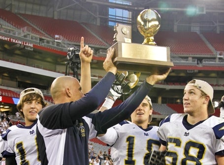 Coach Dan Hinds and the Desert Vista football team hoist the state title trophy last season after knocking off Hamilton. The rematch is Friday.