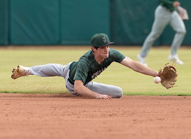 Shortstop Stayton Ankrom of Reagan (Texas) makes a diving stop on a ground ball during a scrimmage game against Brandeis.