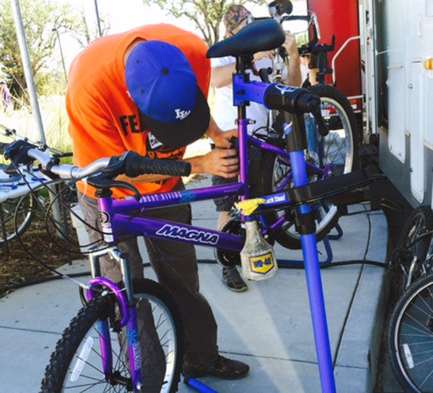 A bike angel puts one of 200 bikes together during a Saturday giveaway at Middletown Middle School. 