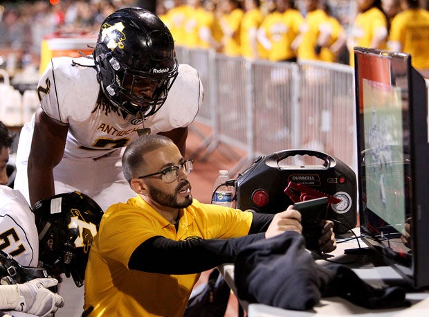 Antioch offensive coordinator Brett Dudley runs through options with Najee Harris while defense is on the field.  