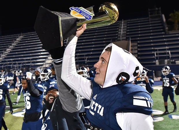 Harrison Bailey proudly displays the GEICO State Champions Bowl Series trophy.