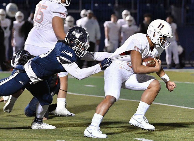 Eastisde Catholic quarterback Kobe Muasau is tackled by a Marietta defender.