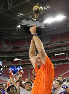 Bishop Gorman coach Tony Sanchez holds
up trophy to celebrate second straight
win for Nevada at Sollenberger Classic. 