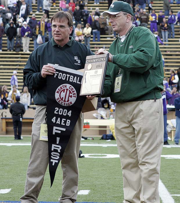Ladouceur along with former principal Brother Christopher Brady proudly display the championship hardware following a victory over Amador Valley in the North Coast Section 4A title game at Memorial Stadium in 2004.