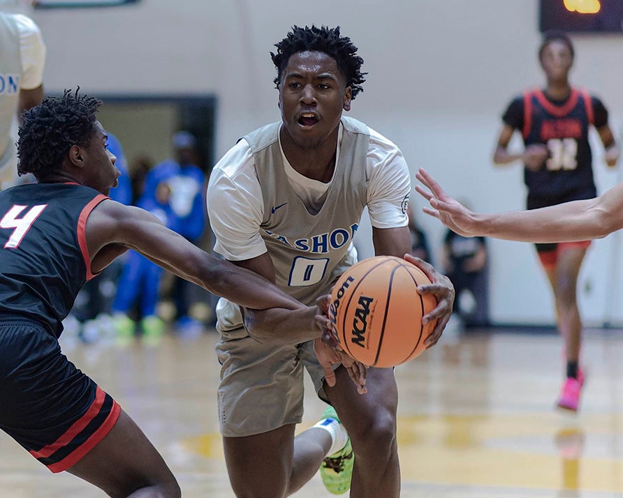 Vashon junior Jimmy McKinney drives to the basket during a recent game vs Alton. The Wolverines hope to extend their state championship win streak to seven in March. (PHOTO: Ricky Slaughter)