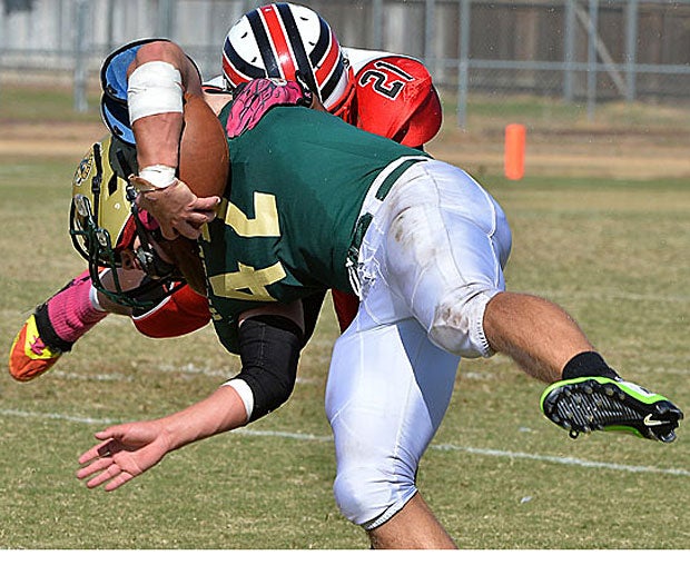 Cordova player (Rancho Cordova, Calif.) Dmitre Jones leaves his feet to tackle Rio Americano (Sacramento) ballcarrier Connor Shatz.