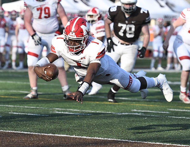 Marist (III.) quarterback Dontrell Jackson dives into the end zone against visiting Chicago Mt. Carmel.