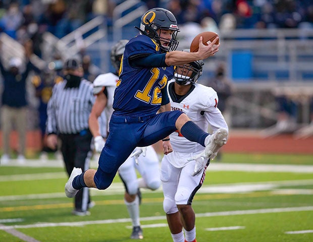 O'Fallon (III.) quarterback Ty Michael leaps into the end zone against Edwardsville.