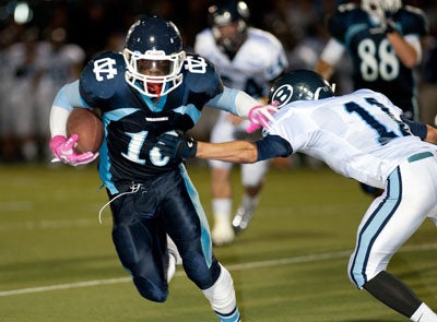 Byron Marshall (10) escapes the tackle of Greg Kenter. 